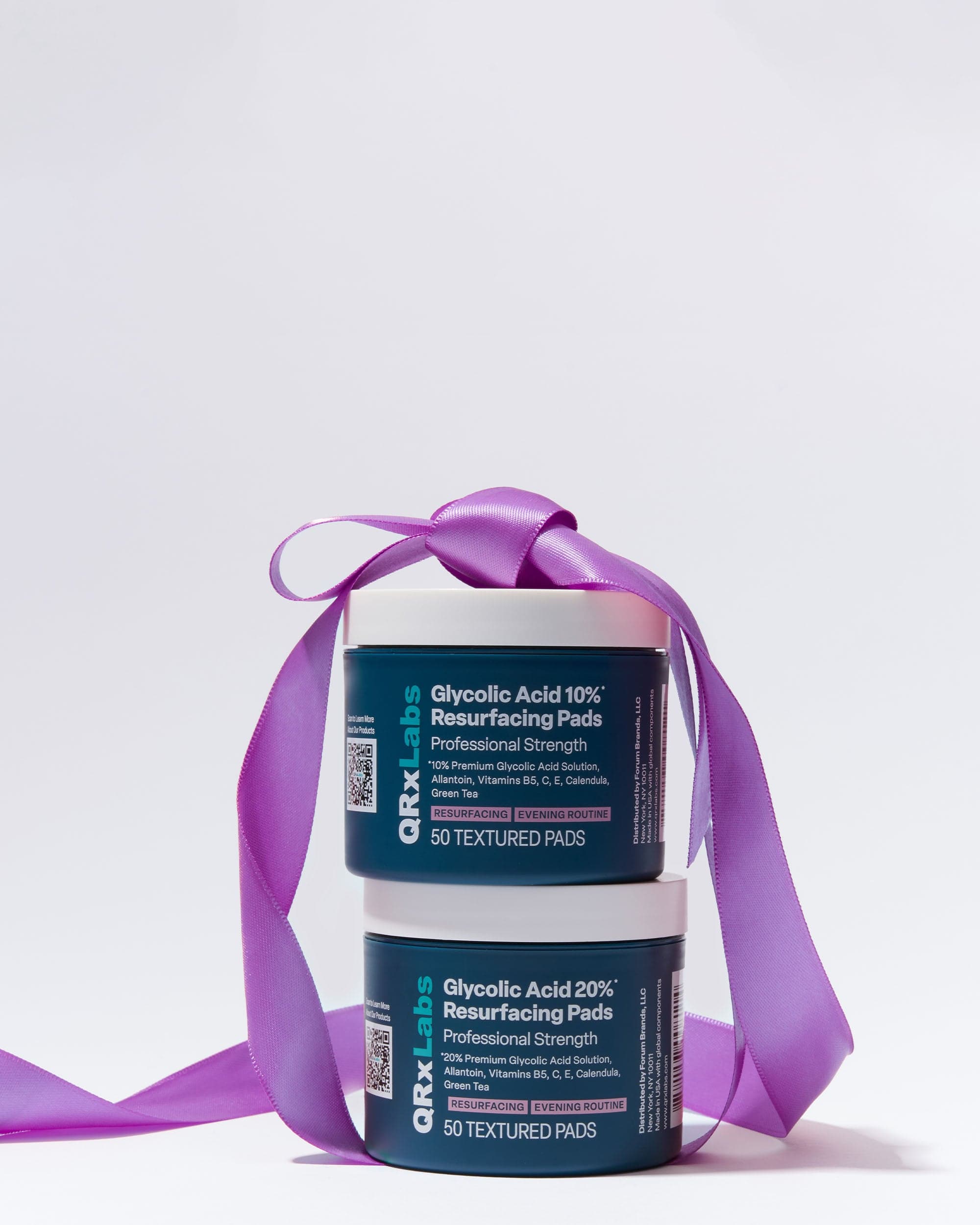Two jars of Glycolic Acid stacked with a purple bow on top.